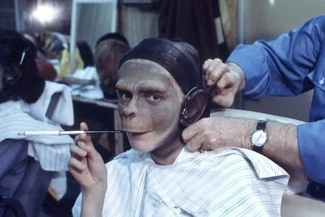 Actress Kim Hunter, who played Zira in the first three Planet of the Apes, smokes while getting into costume.