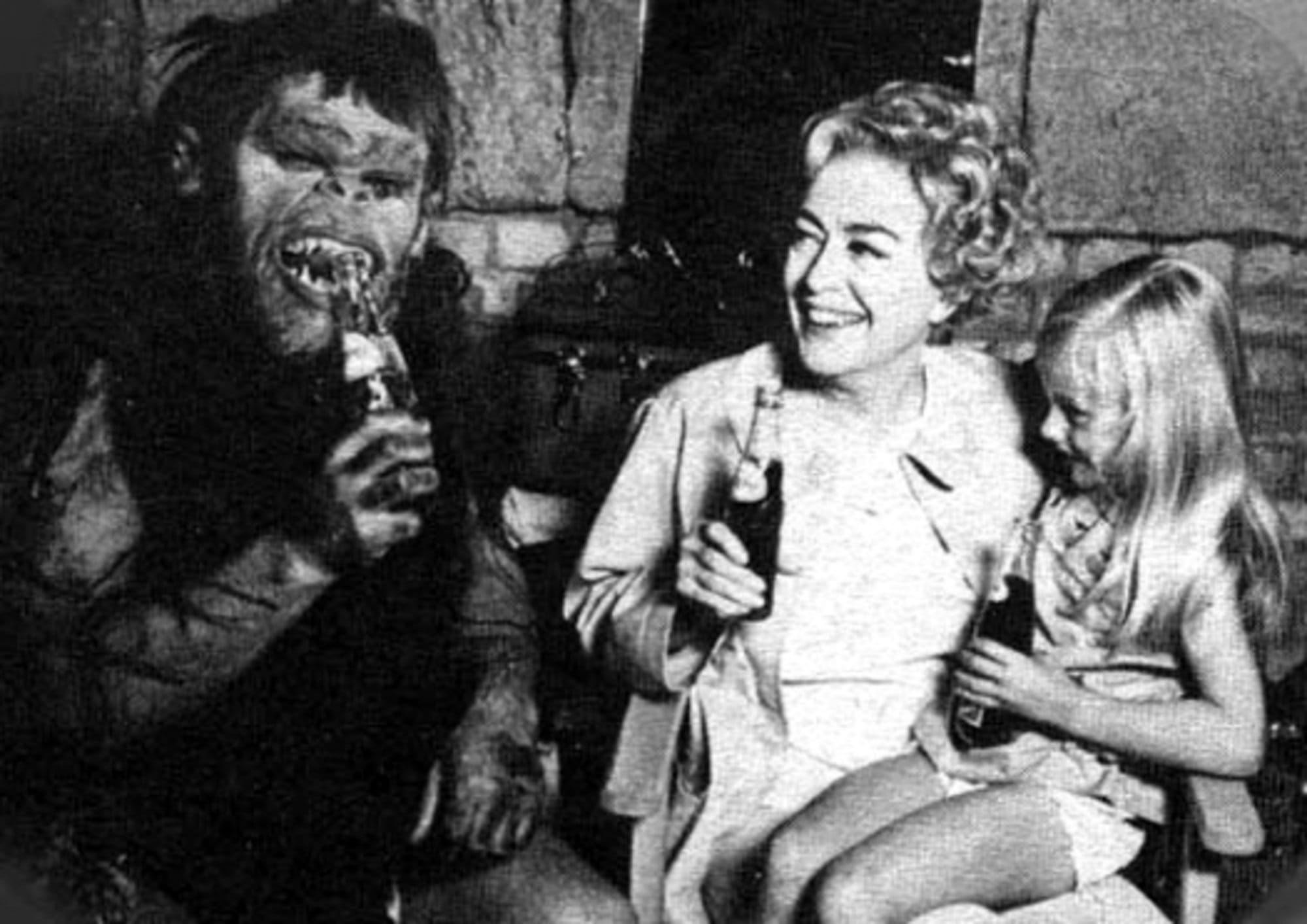 Joan Crawford drinks Pepsi with a kid and someone in a monster costume while on set for her final film, 1970's 'Trog.'