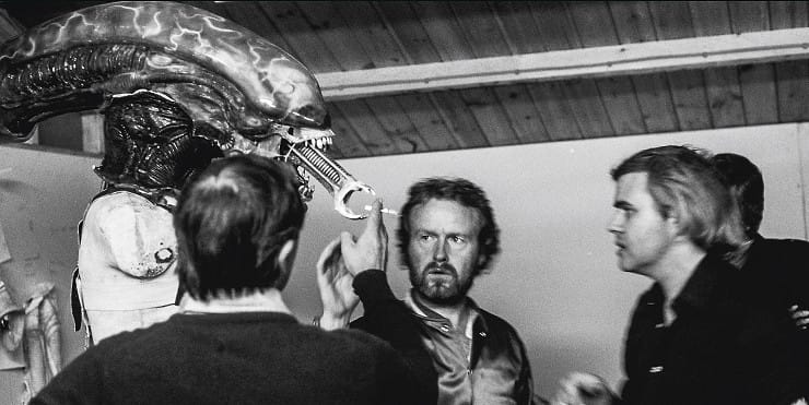 'Alien' director Ridley Scott and designer HR Giger watch as another guy gives the Xenomorph a smoke.